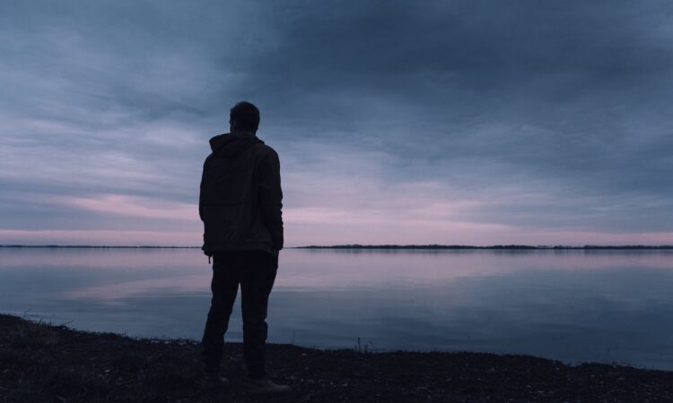 person standing near lake
