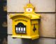 yellow postbriefkasten floating mailbox on brown concrete wall