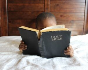 photo of child reading holy bible