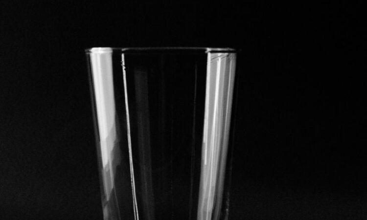 a clear drinking glass on black background