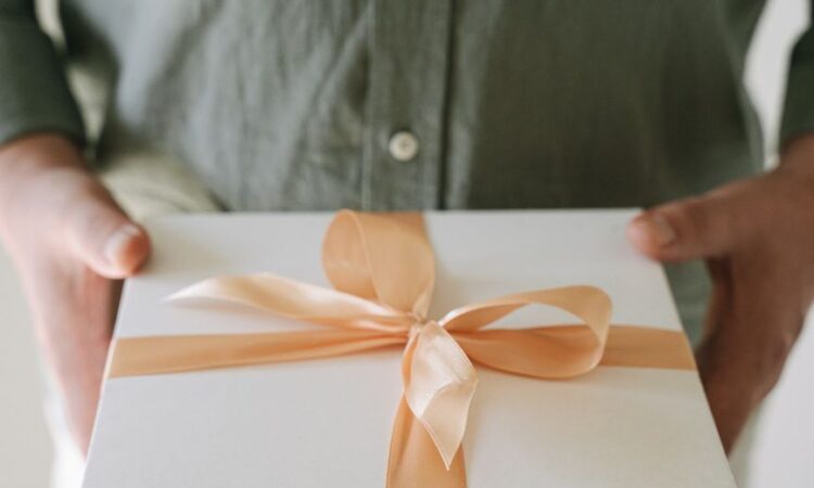 person holding a box with ribbon