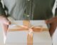 person holding a box with ribbon