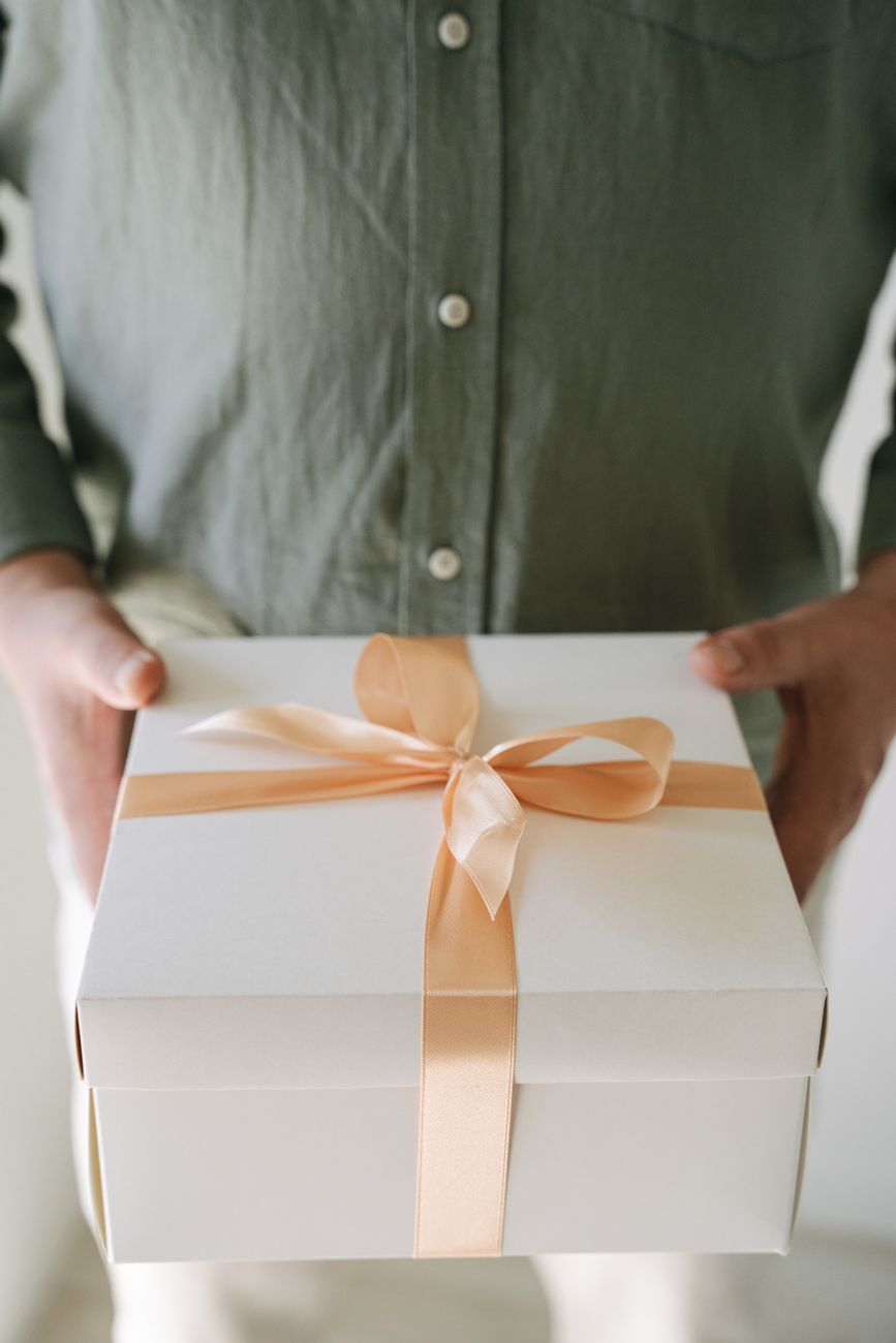 person holding a box with ribbon