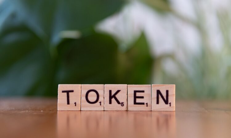 scrabble tiles spelling token on wooden surface