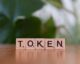scrabble tiles spelling token on wooden surface