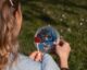 woman reflecting cherry blossoms in handheld mirror