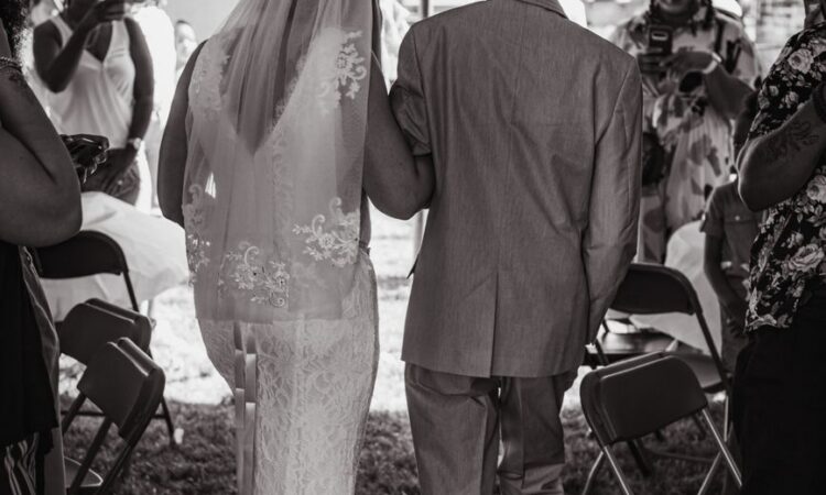 grayscale photo of a bride and her father walking together